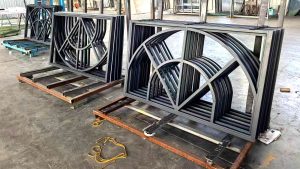 Curved and arched window components with premium RAL7016 coated steel, manufactured for a large 20x40m sunroom frame in a metal fabrication factory.